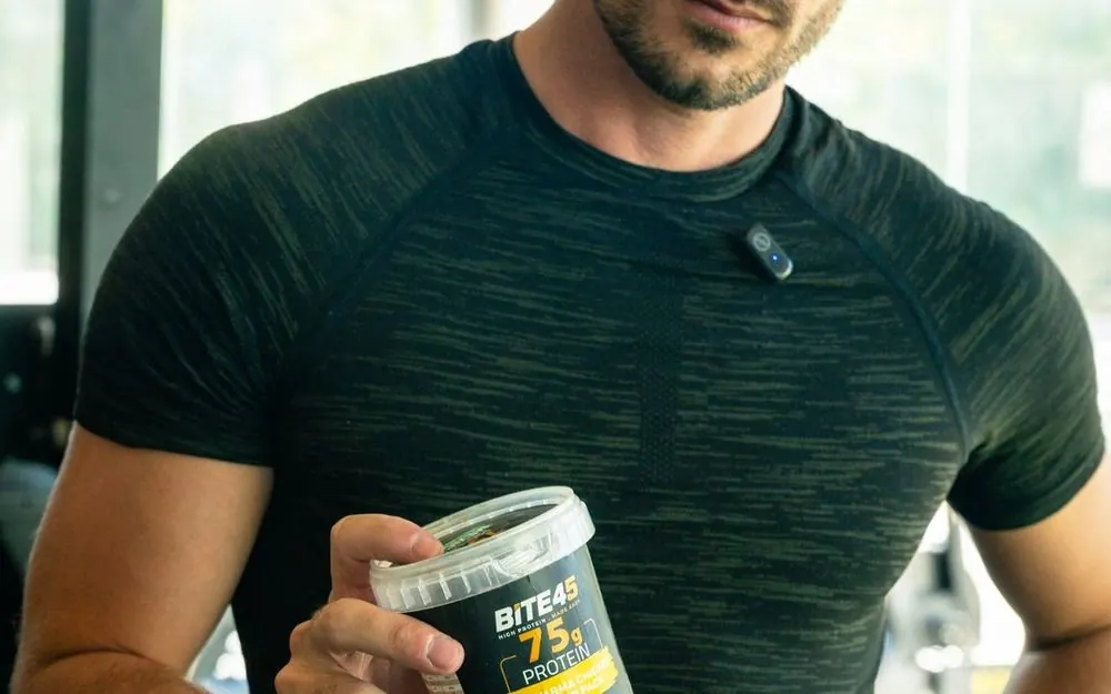 Athlete holding a BITE45 protein pack